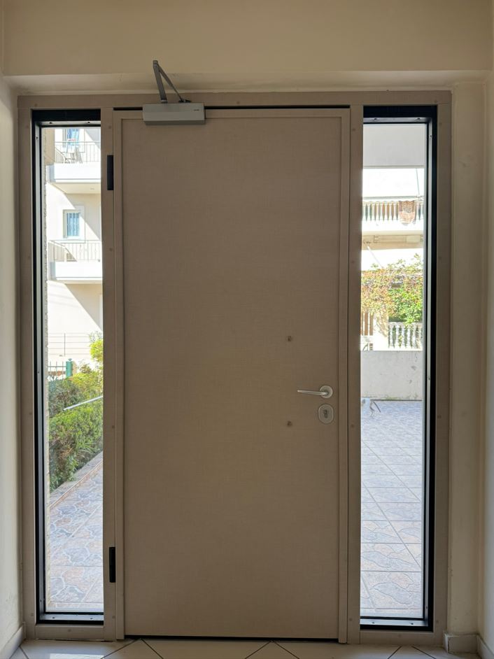Πόρτα εισόδου πολυκατοικίας με πλαϊνά σταθερά και φεγγίτη με επενδυση αλουμινίου2